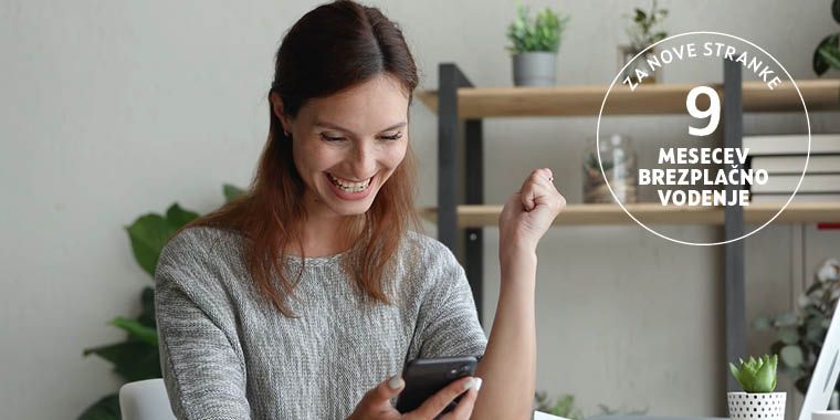 Dekle sedi za pisalno mizo. V eni roki drži pametni telefon, drugo roko ima dvignjeno. Na mizi so listi papirja, pisalo, v ozadju pa so vidne rastline. Na desni strani slike je v krogu napisano besedilo: Za nove stranke 9 mesecev brezplačno.