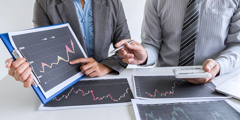 Poslovna ženska in moški gledata grafe