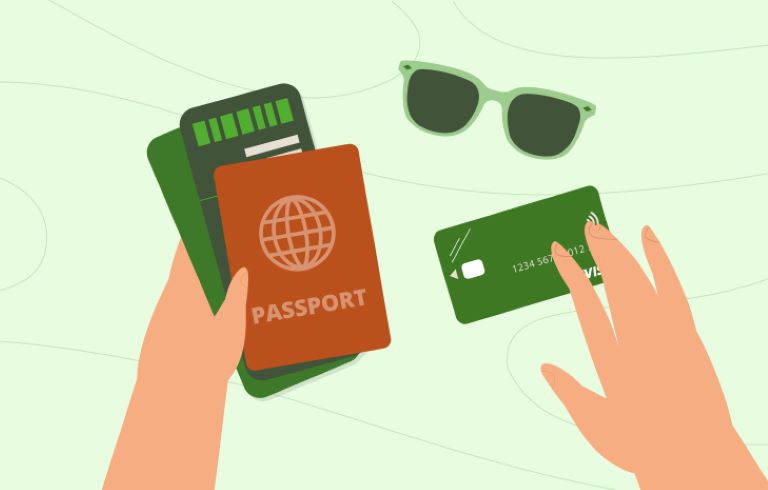 Par rok, ki drži potni list, letalsko karto, pametni telefon in kreditno kartico. Na površini so tudi zelena sončna očala.