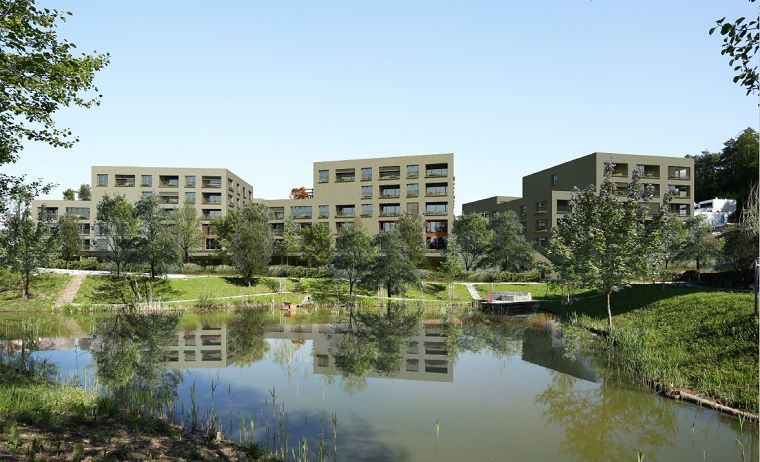 Prikaz stanovanjskega kompleksa Črnuški bajer, obdanega z ribnikom in zelenimi drevesi.