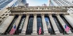 Pročelje newyorške borze (NYSE) z mogočnimi stebri in ameriškimi zastavami.jpg