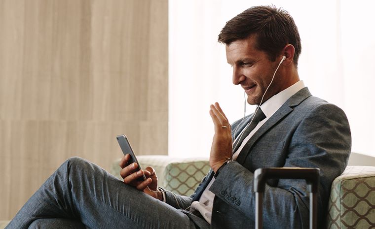 Poslovni moški v letališkem salonu opravlja videoklic