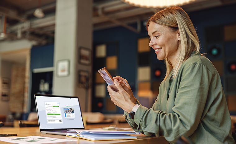 Ženska uporablja pametni telefon za aktivacijo mobilnega žetona v mobilni banki mBank@Net.